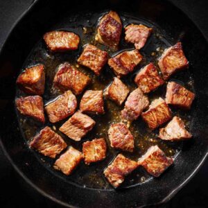Browning steak in a skillet for steak and beef chili recipe